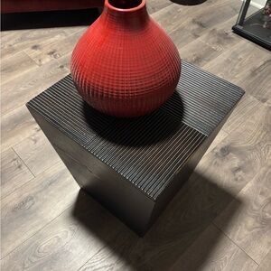 Red Textured Vase on Black Wooden Storage Cube